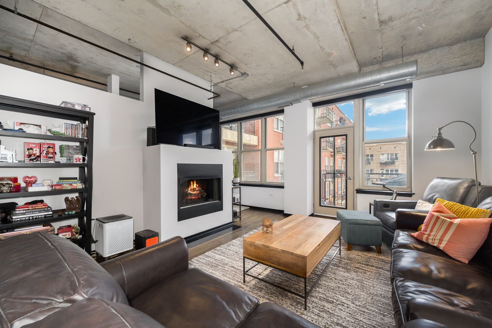 6 South Laflin Street, Unit 722 Chicago, IL 60607 - Photo 6 of 16 a living room with furniture a flat screen tv and a fireplace