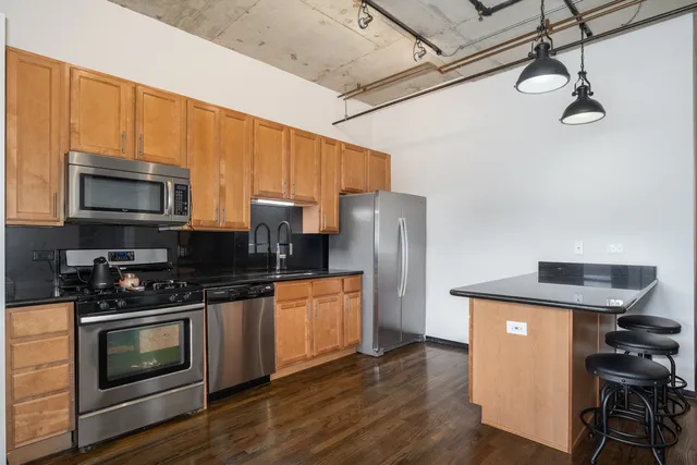 a kitchen with stainless steel appliances a stove a refrigerator and a microwave