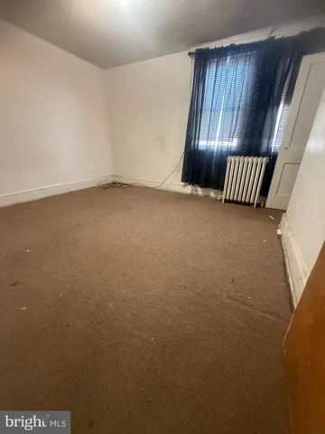 a view of an empty room and wooden floor