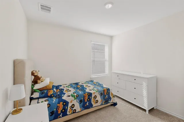 a bedroom with a bed and a dresser in it