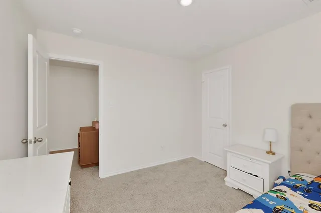 a view of a bedroom with baby bed and closet