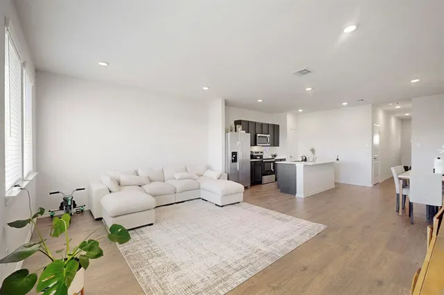 a living room with furniture and kitchen view