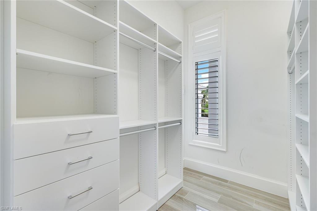 9937 Montiano Court Naples, FL 34113 - Photo 13 of 25 a view of walk in closet with empty racks