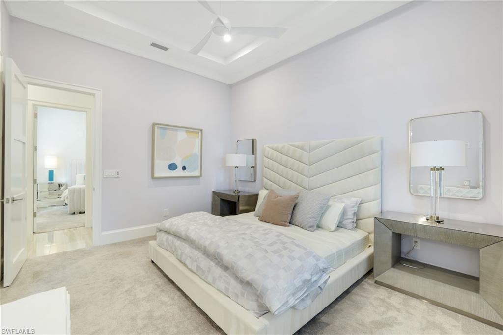 9937 Montiano Court Naples, FL 34113 - Photo 18 of 25 a bedroom with a large bed and a couch
