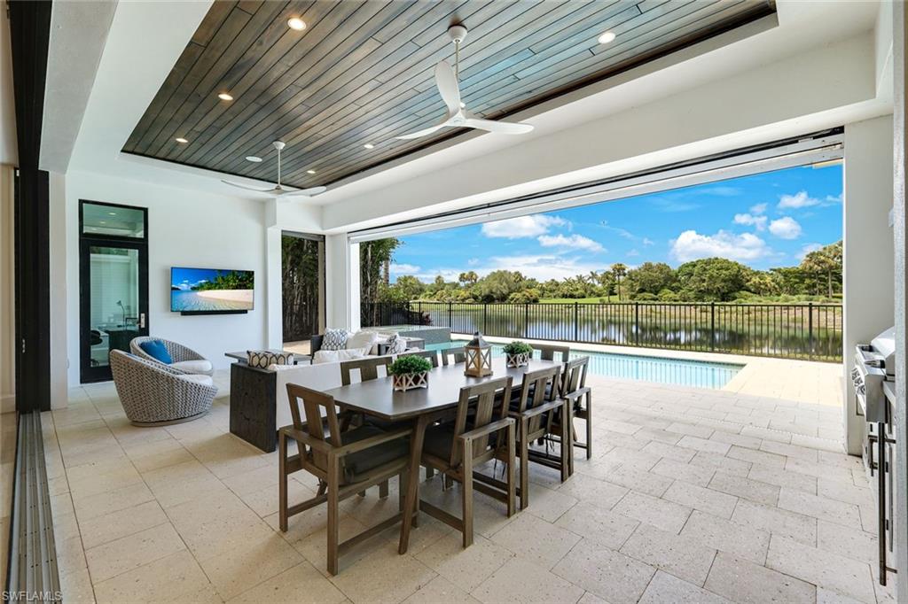 9937 Montiano Court Naples, FL 34113 - Photo 20 of 25 a view of a patio with a dining table and chairs