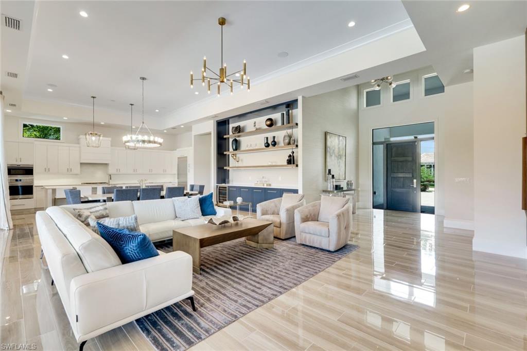 9937 Montiano Court Naples, FL 34113 - Photo 3 of 25 a living room with furniture kitchen view and a chandelier