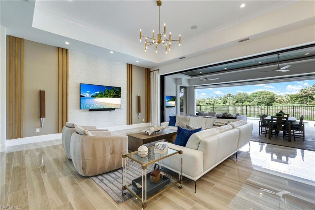 9937 Montiano Court Naples, FL 34113 - Photo 4 of 25 a living room with furniture and a chandelier