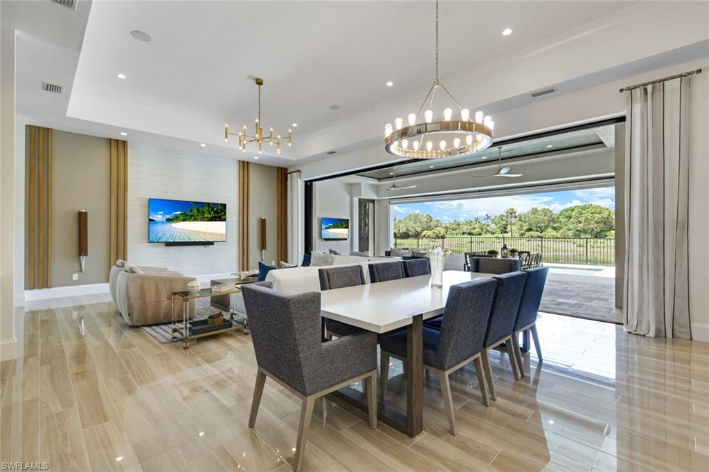 9937 Montiano Court Naples, FL 34113 - Photo 5 of 25 a view of a dining room with furniture wooden floor and chandelier