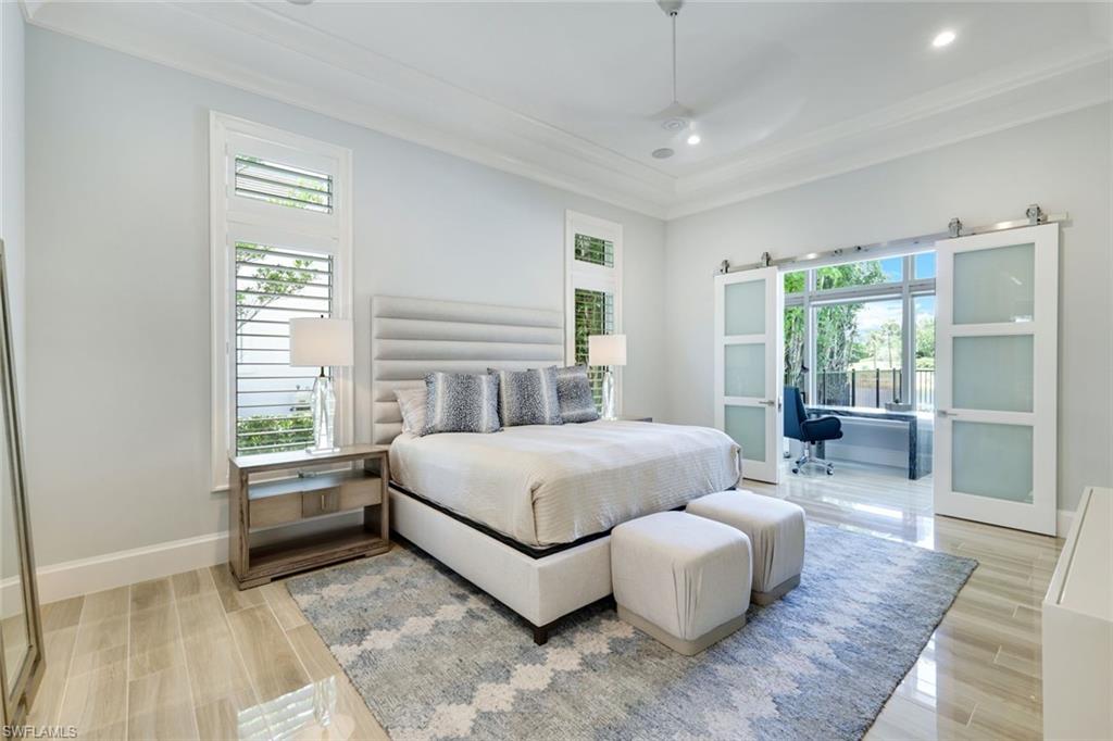 9937 Montiano Court Naples, FL 34113 - Photo 9 of 25 a bedroom with a large bed and a couch