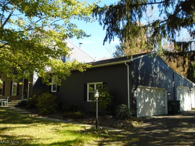 10971 Auburn Road Chardon, OH 44024 - Photo 34 of 40 View of property exterior with a garage, driveway, and a yard