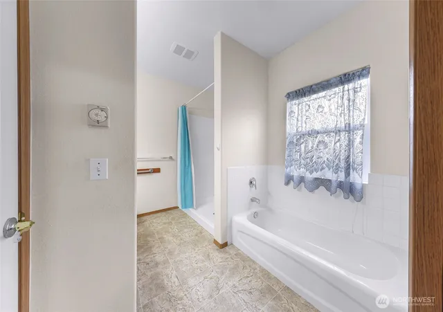 a bathroom with bathtub and shower