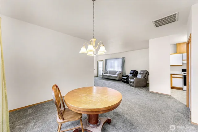 a view of a dining room with furniture and a chandelier