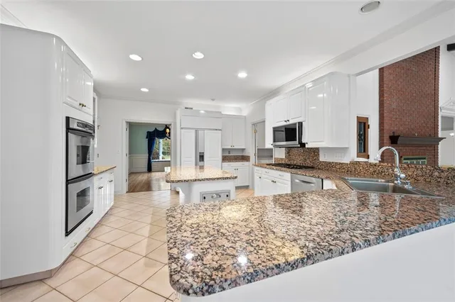 a large kitchen with kitchen island granite countertop a large counter top stainless steel appliances and cabinets