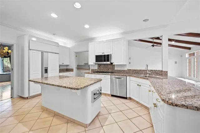 a kitchen with granite countertop cabinets stainless steel appliances and a counter space