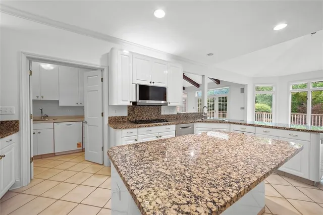a large kitchen with kitchen island granite countertop a sink and cabinets