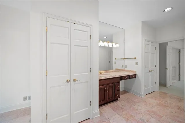 a spacious bathroom with a granite countertop sink a mirror and a vanity