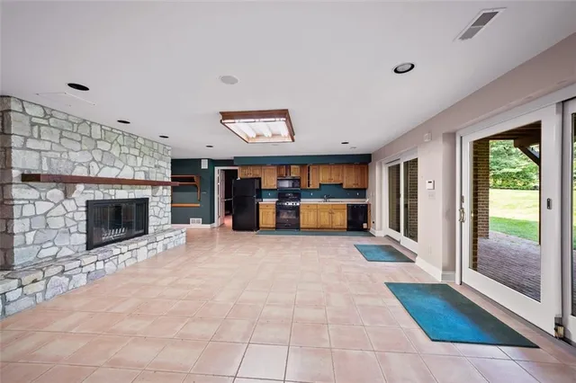 a view of an empty room with a fireplace and a window