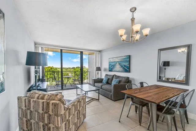 a living room with furniture a chandelier and a flat screen tv