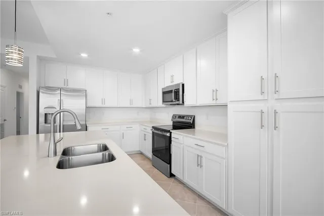 a kitchen with white cabinets and stainless steel appliances