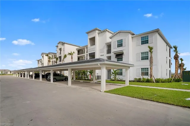 a view of a house with a big yard and large trees