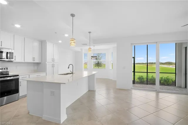 a large kitchen with kitchen island a large window in it