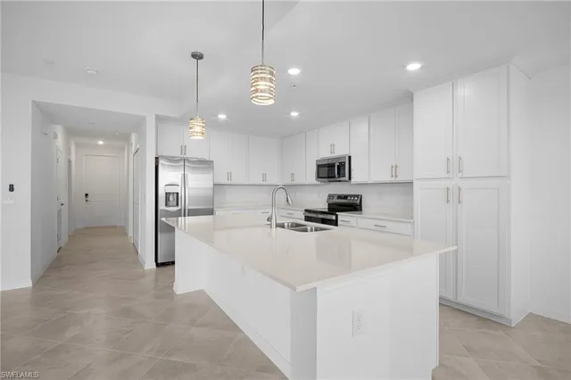 a kitchen with stainless steel appliances a refrigerator sink and white cabinets