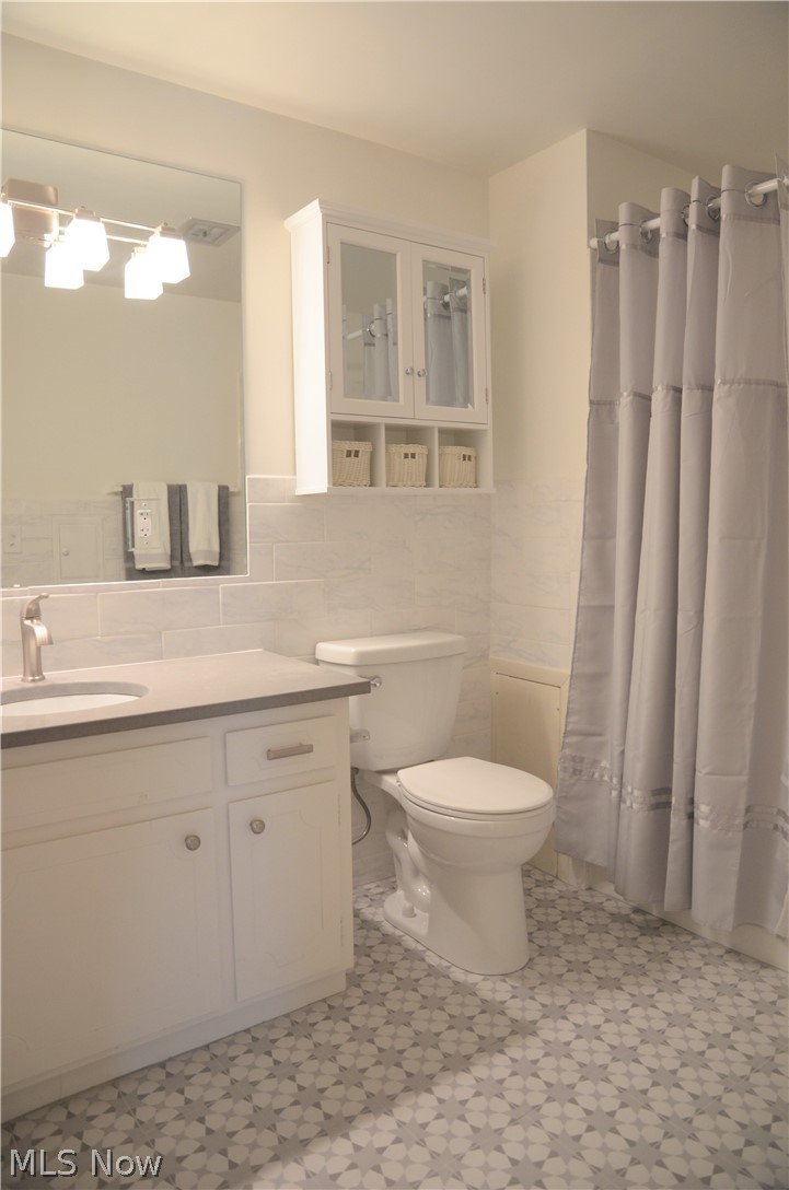 1047 Roland Road Lyndhurst, OH 44124 - Photo 18 of 26 The Bathroom was completely updated with new and modern Wall Tile, Mirror and the Vanity Lights, Quartz Countertop and Plumbing Fixture, and with Italian Floor Tiles.