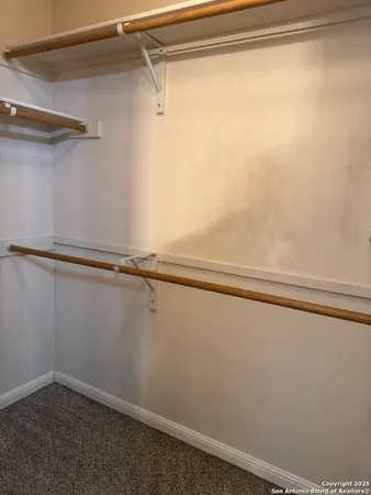 a view of an empty room with a window and fireplace