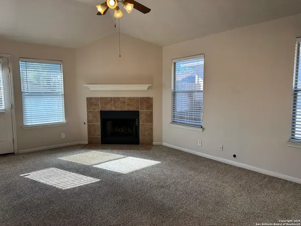 en empty room with windows and chandelier
