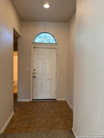 an empty room with wooden door and windows