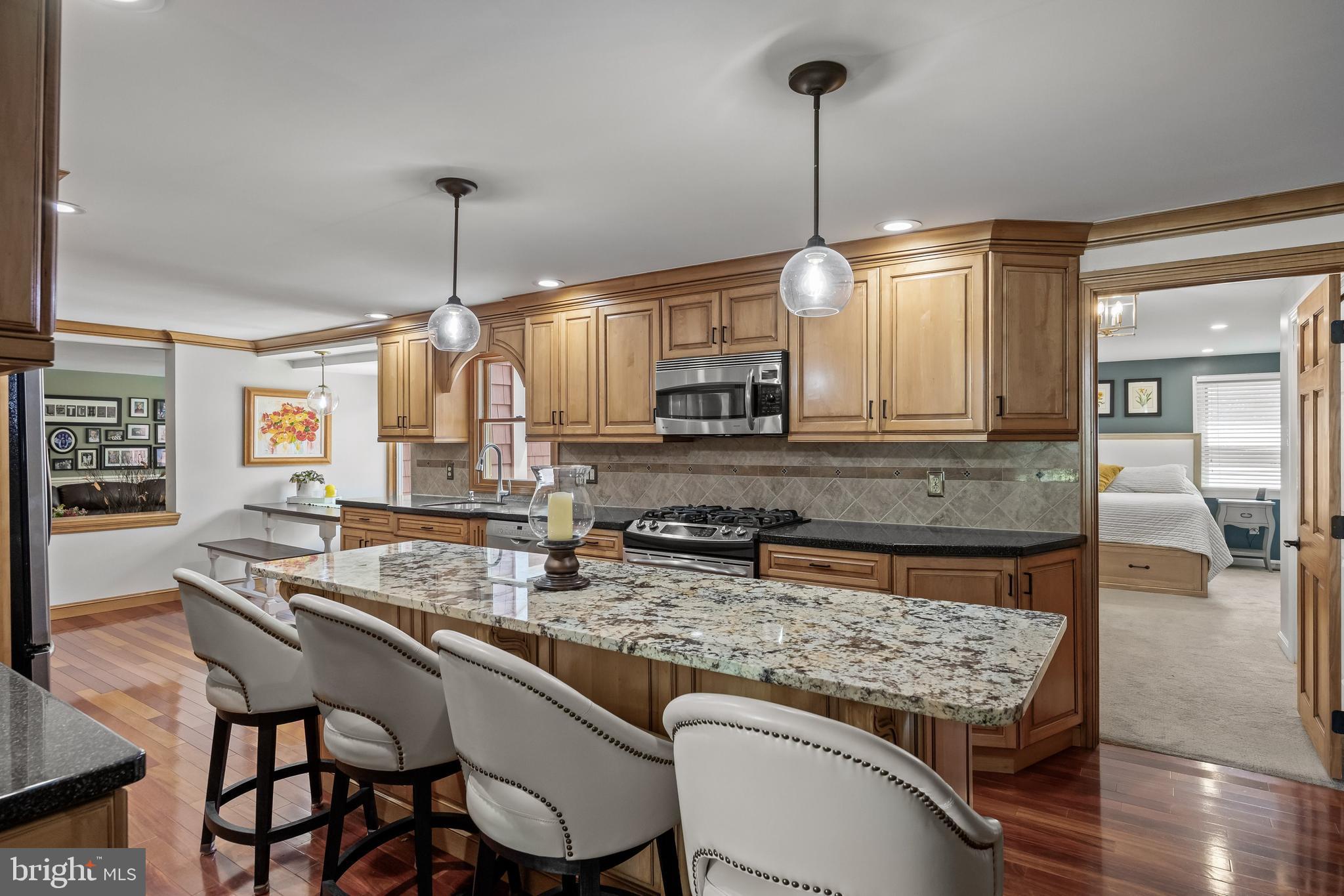 4 Sequoia Drive Cinnaminson, NJ 08077 - Photo 8 of 37 a kitchen with granite countertop a stove a sink dishwasher a dining table and chairs with wooden floor