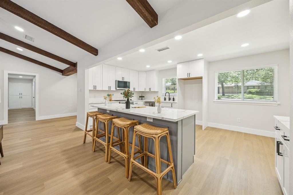 37 Devonshire Bedford, TX 76021 - Photo 13 of 39 a kitchen with stainless steel appliances granite countertop a kitchen island a stove a refrigerator a sink a dining table and chairs with wooden floor