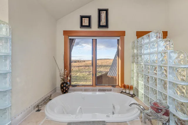 a white bath tub sitting in a bathroom next to a window