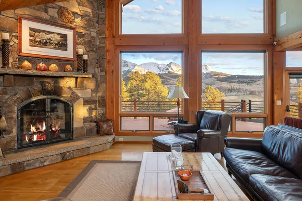 a living room with furniture fireplace and floor to ceiling windows