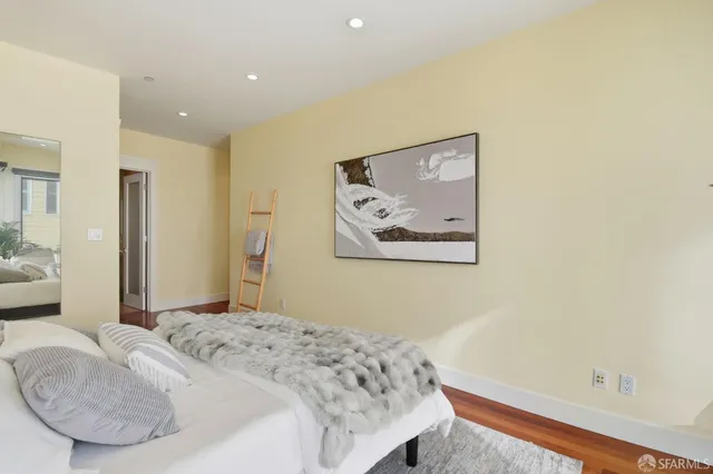 a bedroom with a bed and a painting on the wall