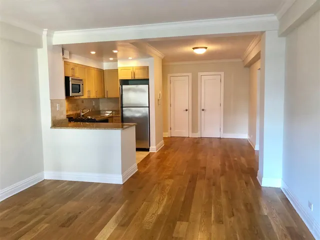 a view of a kitchen with a sink and wooden floor