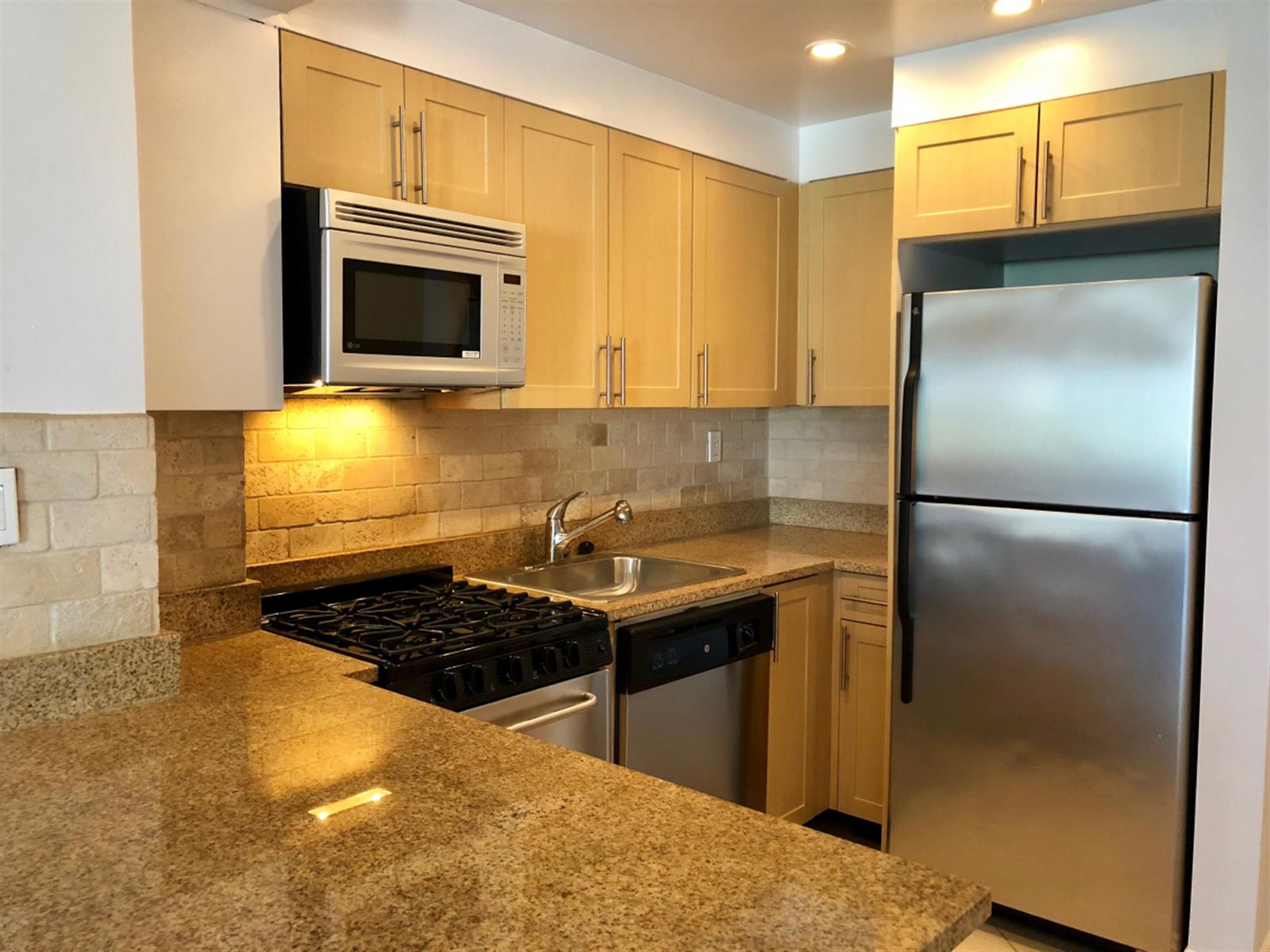 41 Park Avenue, Unit 7B Manhattan, NY 10016 - Photo 3 of 9 a kitchen with stainless steel appliances granite countertop a refrigerator and a stove top oven