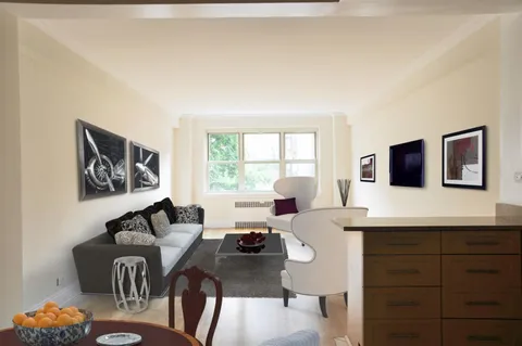 a living room with furniture a computer on the desk and a large mirror next to a window