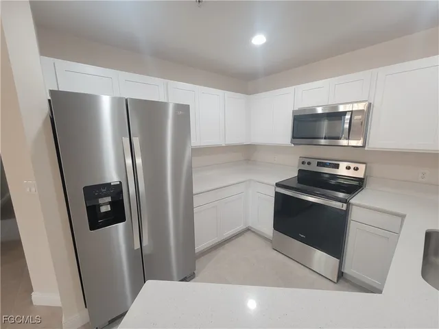 a kitchen with stainless steel appliances a refrigerator a stove a microwave and cabinets