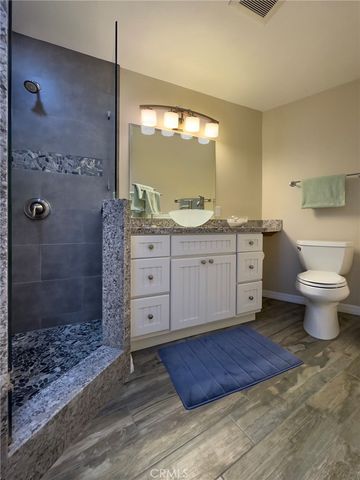 a bathroom with a granite countertop sink a toilet and shower