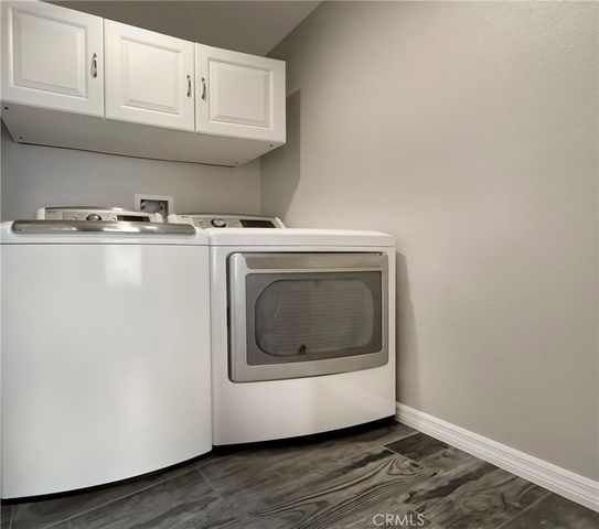 a utility room with wooden floor washer and dryer