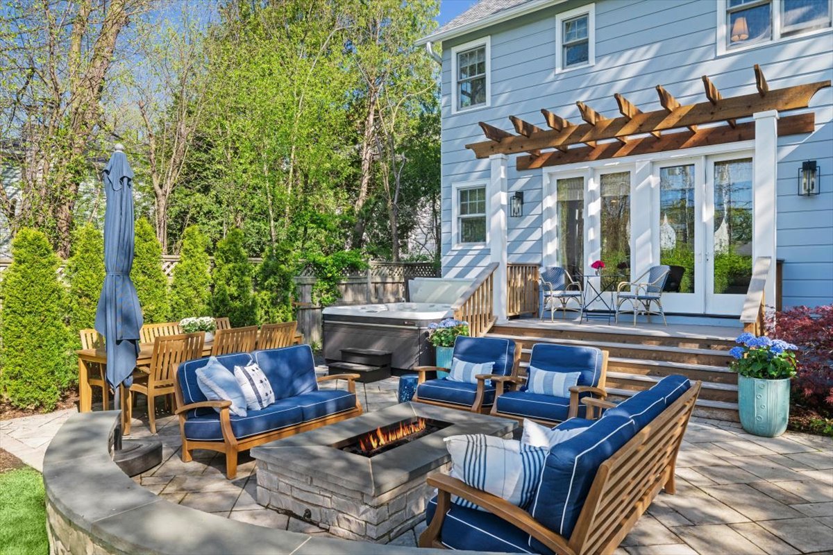1082 Ash Street Winnetka, IL 60093 - Photo 18 of 54 a view of a patio with couches table and chairs potted plants and large tree