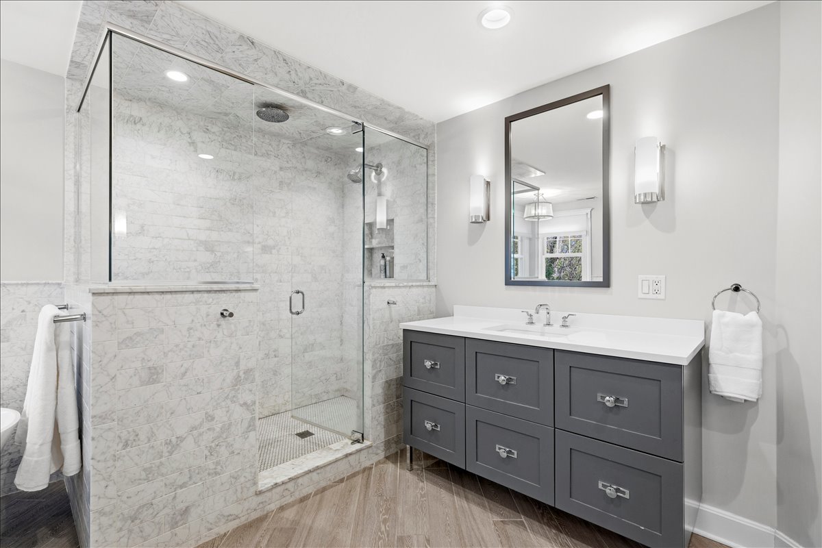 1082 Ash Street Winnetka, IL 60093 - Photo 31 of 54 a bathroom with a granite countertop sink a mirror a shower and a bathtub