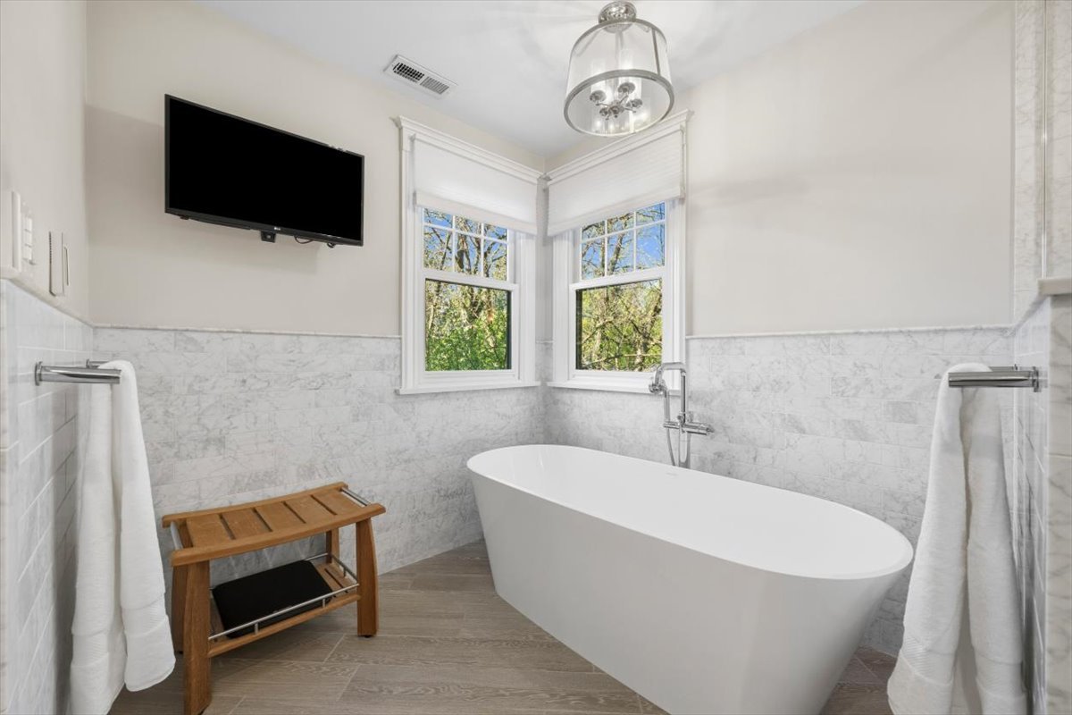 1082 Ash Street Winnetka, IL 60093 - Photo 33 of 54 a bathroom with a sink a window and a flat screen tv