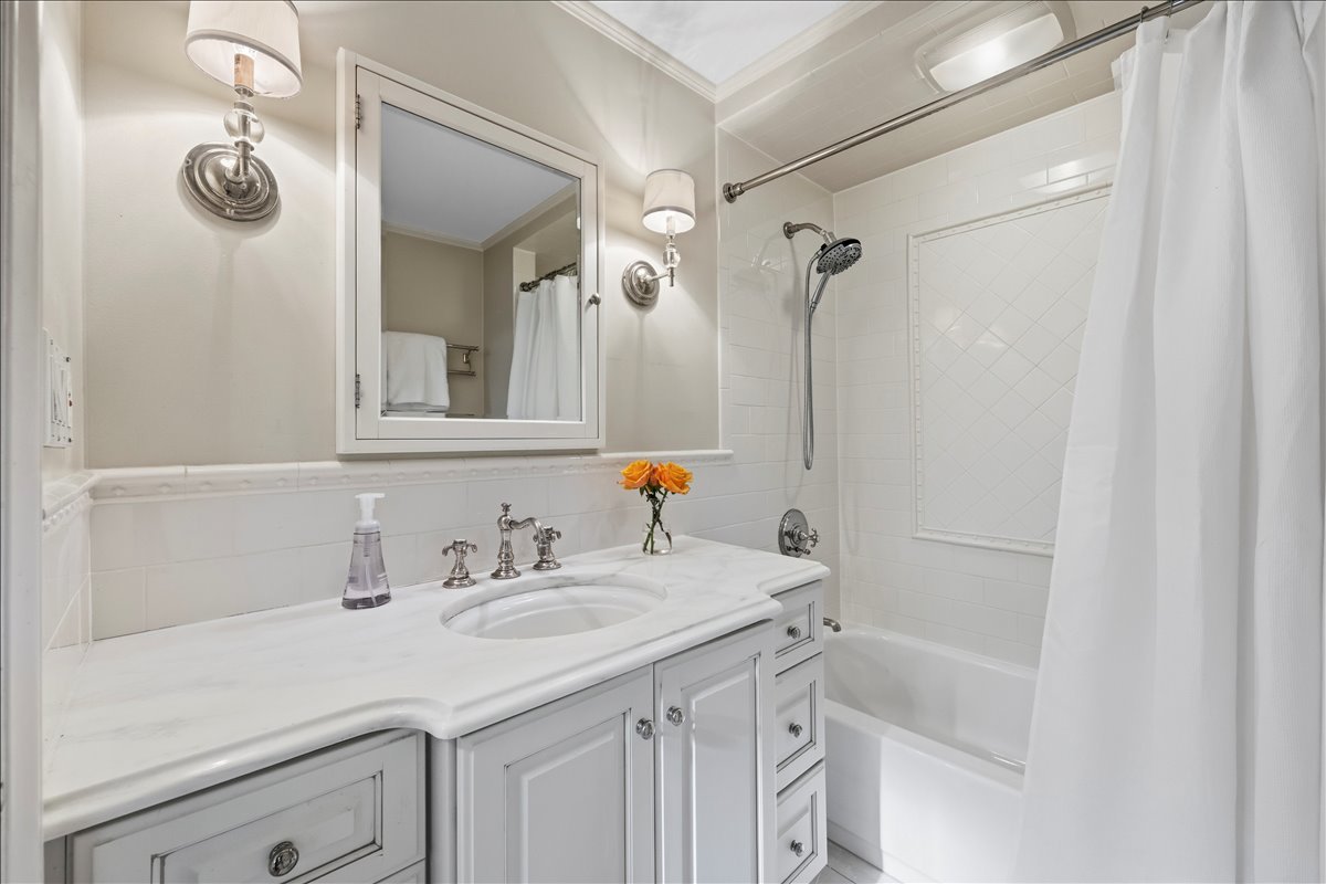 1082 Ash Street Winnetka, IL 60093 - Photo 39 of 54 a bathroom with a sink vanity granite tub shower and a mirror