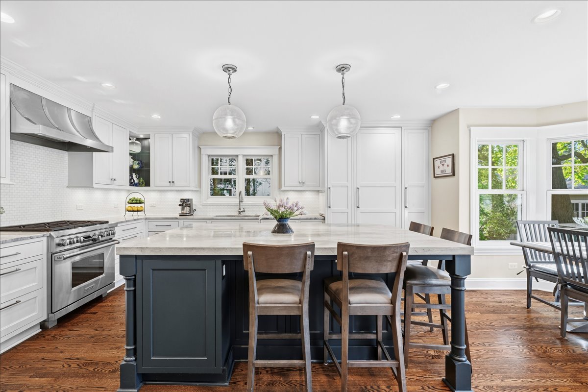 1082 Ash Street Winnetka, IL 60093 - Photo 7 of 54 a kitchen with lots of white furniture appliances and wooden floor