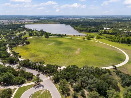 an aerial view of residential houses with outdoor space and lake view