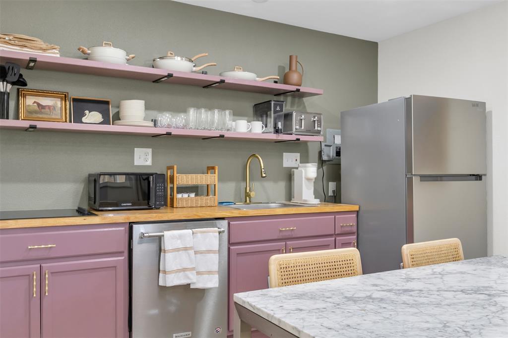 4121 Junius Street, Unit B Dallas, TX 75246 - Photo 32 of 32 Kitchenette featuring butcher block countertops, purple base cabinetry with gold-tone hardware, a stainless steel refrigerator, and a stainless steel dishwasher