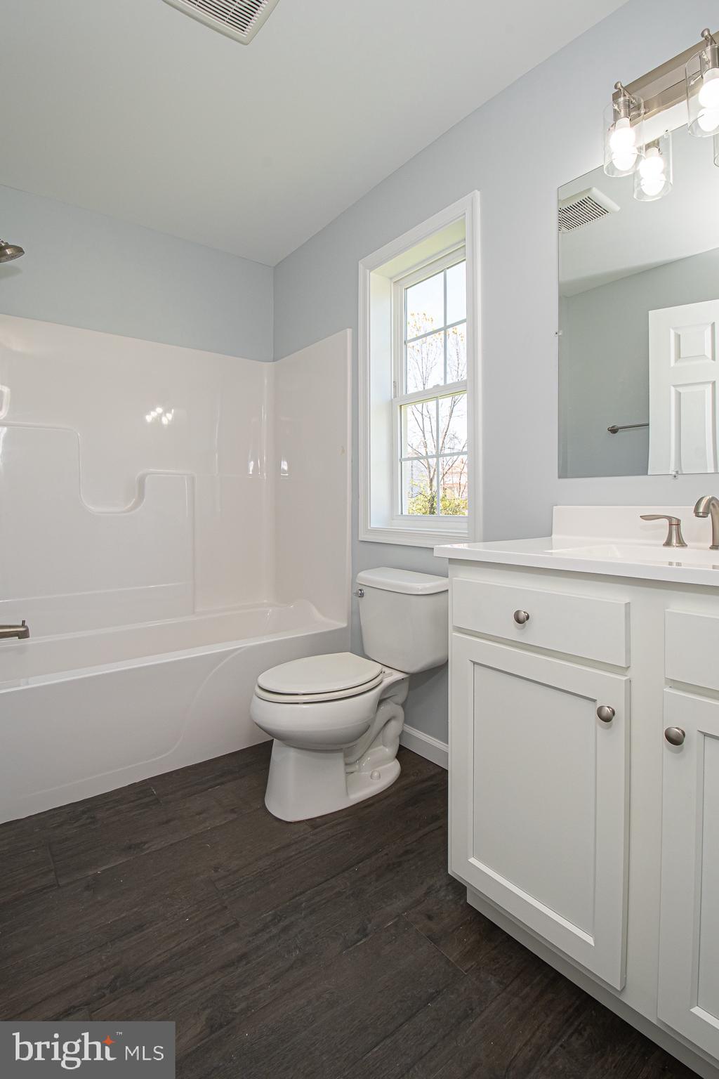 709 Ross Street Winchester, VA 22601 - Photo 23 of 40 a bathroom with a toilet sink a mirror and a bathtub