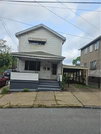 a view of a house with a small yard and wooden fence